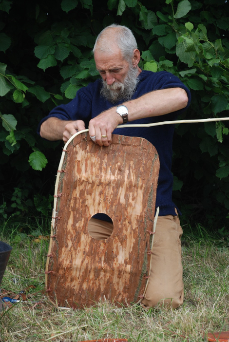 An experimental archaeologist reconstructing the bark shield.